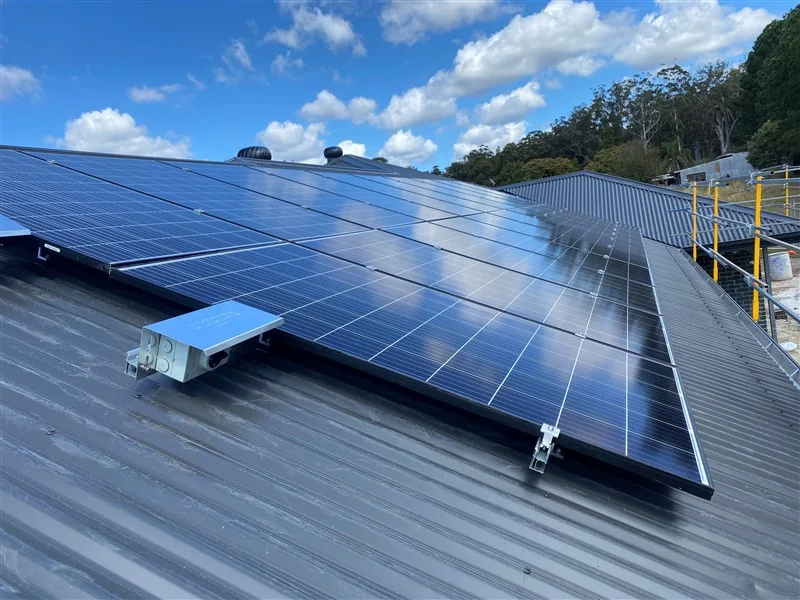 Black-framed panels on a Colorbond roof under a clear blue sky