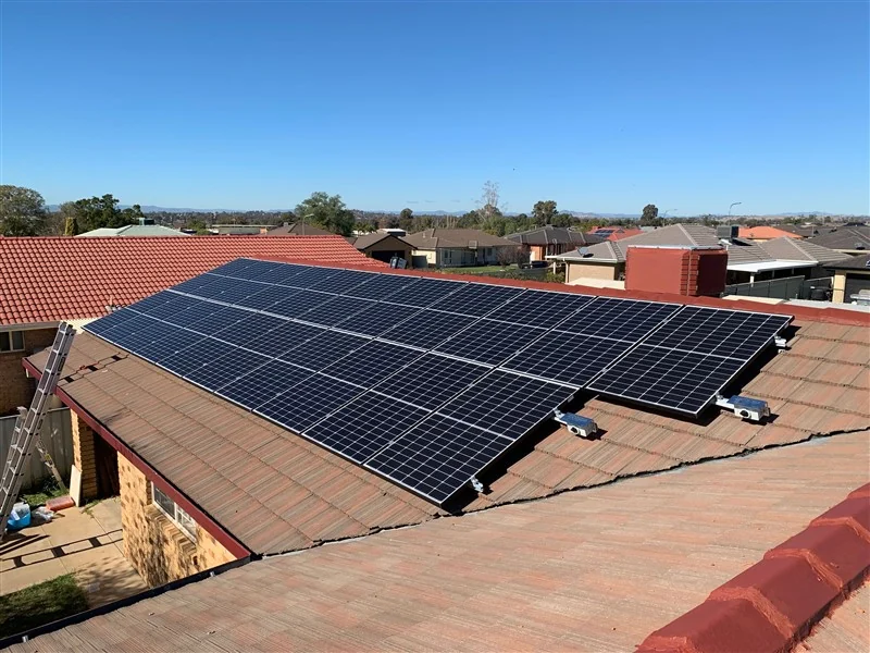 Solar panels on a terracotta tiled roof, street view